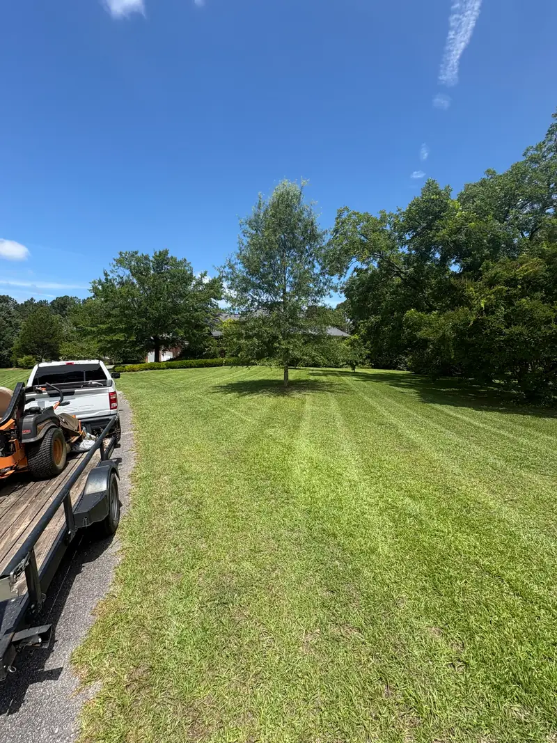 Freshly mowed open frontage with the crew's trailer at the curb