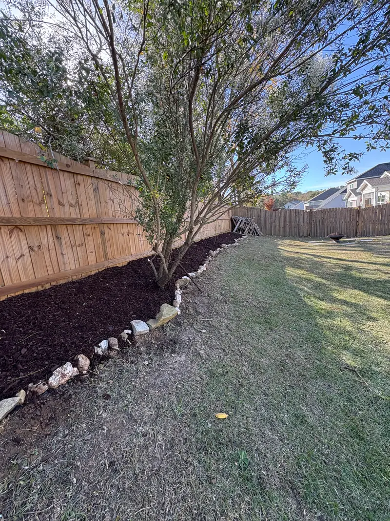 Stone-edged mulch bed beneath a crape myrtle