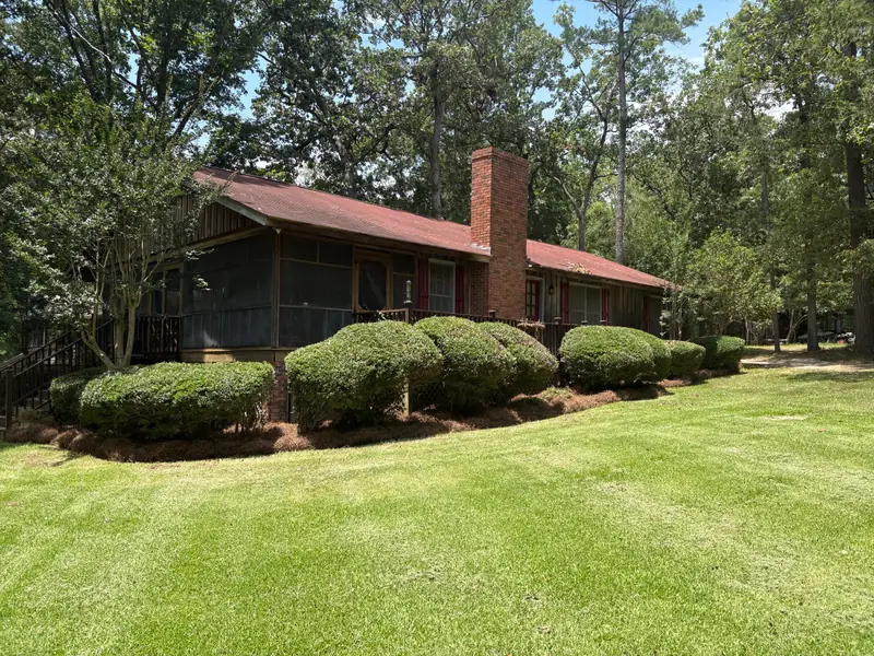 Rounded shrubs and open lawn at a brick ranch home