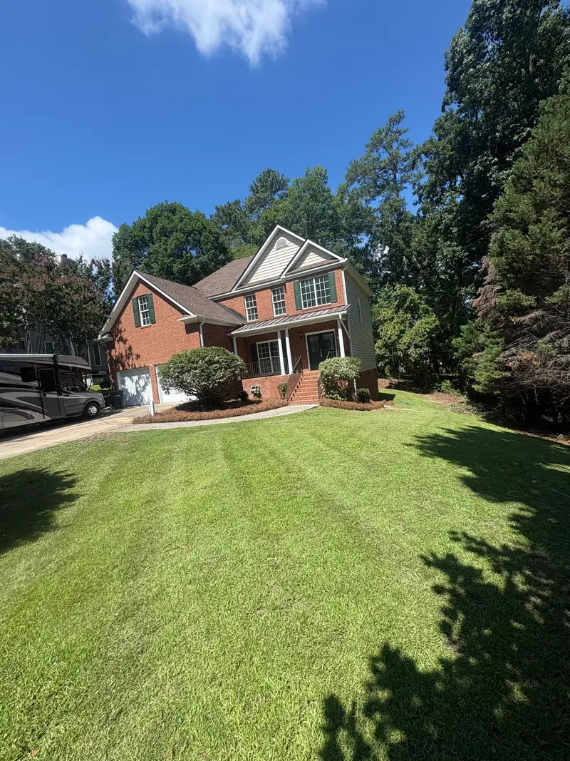 Striped lawn at a brick two-story home